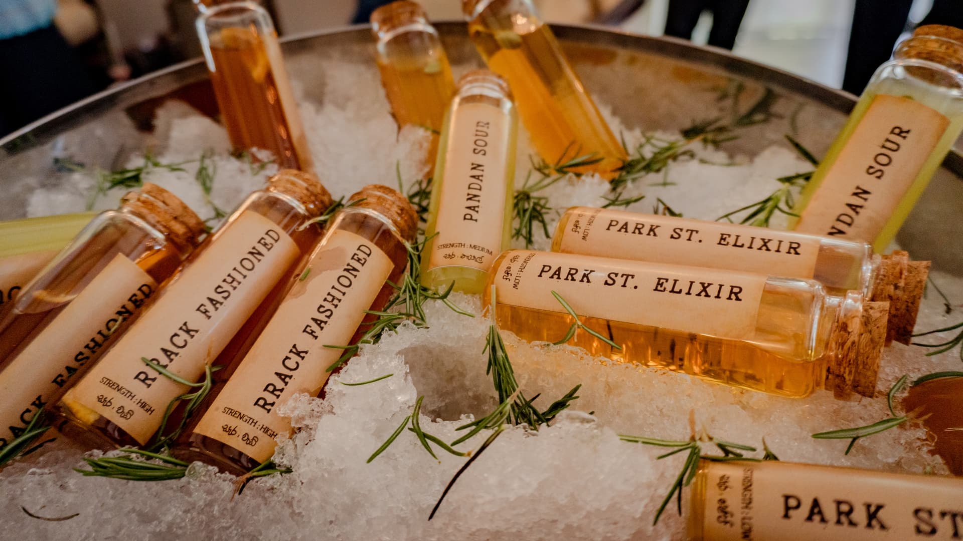 Bottles on ice with herbs, cool light, seasonal ritual